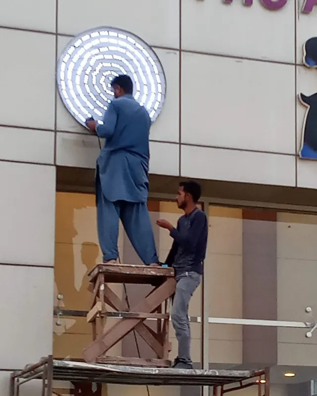 Azan Enterprises team fitting an LED sign on a building front